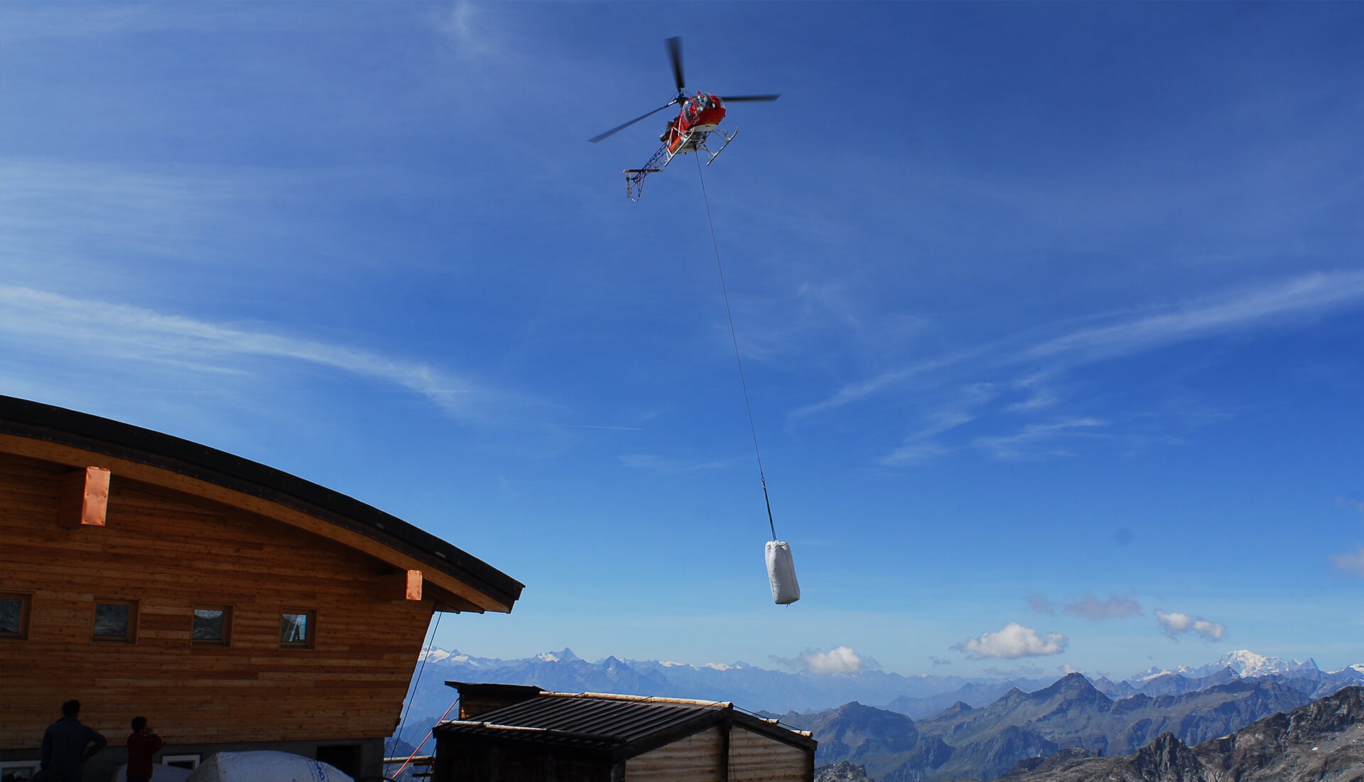Baustoffe werden mit Helikopter auf Berg transportiert